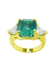A GIA-certified natural Muzo Colombian emerald ring, featuring trillion-cut side diamonds and crafted in 18k gold.
