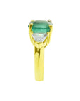 18k yellow gold ring with a large natural colombian emerald and two trillion side diamonds.