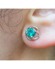 A tulip natural colombian emerald stud earring in 14k white gold on an ear.