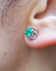 Close-up of an ear wearing a 14k white gold emerald tulip stud earring underside view.