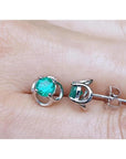 Tulip emerald stud earrings with round cut green emeralds set in 14K white gold.
