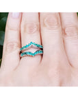 14k white gold emerald ring enhancer with 22 round cut Colombian emeralds, worn on a finger.