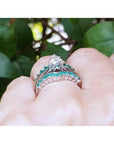 14k white gold emerald ring enhancer with 22 round cut Colombian emeralds, worn with a solitaire ring.