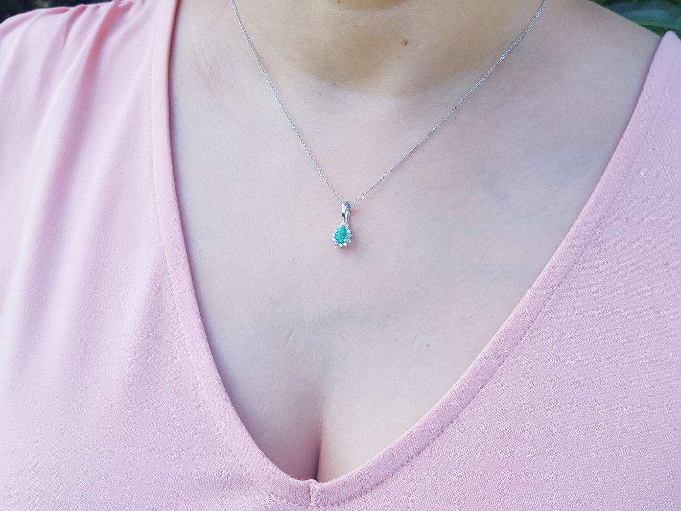 A Colombian emerald necklace enhancer on a person's neck.