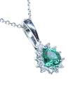 White gold enhancer pendant with a natural emerald gemstone on a right topside position.