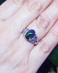 Ring with an opal stone on a hand, with a natural background