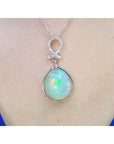 Ethiopian Welo opal and diamond pendant in 14K white gold, worn on a neck.