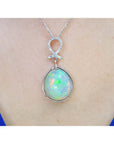 Ethiopian Welo opal and diamond pendant in 14K white gold, worn on a neck.