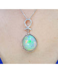 Ethiopian Welo opal and diamond pendant in 14K white gold, worn on a neck.