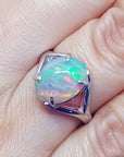 Opal ring with a silver setting on a finger