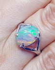 Ethiopian opal sterling silver ring with an oval cut, displaying vibrant red, orange, and green play of color.