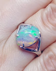 Ethiopian opal sterling silver ring with an oval cut, displaying vibrant red, orange, and green play of color.