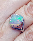 Ethiopian opal sterling silver ring with an oval cut, displaying vibrant red, orange, and green play of color.