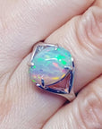 Ethiopian opal sterling silver ring with an oval cut, displaying vibrant red, orange, and green play of color.