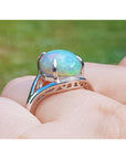 Ethiopian opal silver ring for women, oval cut, showing red and orange play of colors.