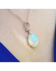 Ethiopian Welo opal and diamond pendant in 14K white gold on a woman's neck.