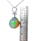 Ethiopian Welo opal and diamond pendant in 14K white gold, shown with a ruler for scale.