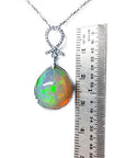 Ethiopian Welo opal and diamond pendant in 14K white gold, shown with a ruler for scale.