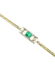 14K yellow gold bracelet with a central emerald-cut Colombian emerald and diamond accents.