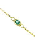 Gold bracelet with a natural colombian emerald on a topside view.