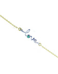 White and yellow gold 'love' bracelet with a round natural emerald on a white background