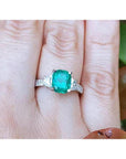 Cushion cut side trapezoid natural diamond ring for women in white gold on a finger.