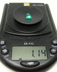 Heart cut loose natural colombian emerald on a digital scale showing weight