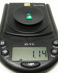 1.14 carat heart-cut Colombian emerald on a black digital jewelry scale.