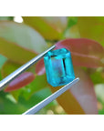 Untreated 3.98 ct loose emerald from Muzo mines, vibrant bluish-green, held by tweezers.