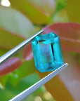 Untreated 3.98 ct loose emerald from Muzo mines, vibrant bluish-green, held by tweezers.