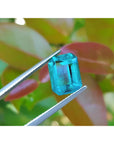 Untreated 3.98 ct loose emerald from Muzo mines, vibrant bluish-green, held by tweezers.
