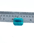 Certified 3.98 ct emerald-cut Muzo emerald with vibrant bluish-green hue, shown next to a ruler for scale.