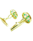 Gold cufflinks with colombian emeralds, downside profile view on a white background