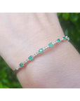 This natural colombian emerald bangle bracelet is flexible, and it is decorated with accent natural diamonds.
