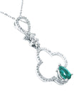 Diamond necklace four-leafe with a central emerald stone on a white background.