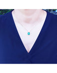 Front view of a Muzo Colombian emerald necklace yellow gold on a lady's collar