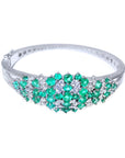 14k white gold bangle bracelet with round Colombian emeralds and diamonds.