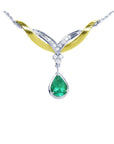 A front view of a solitaire emerald dangling necklace crafted in 14k white and yellow gold on a white background