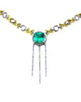 Front view of an necklace with a square natural emerald gemstone and gold and silver chain on a white background