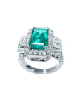 Anillo de compromiso de oro blanco 18k con esmeralda colombiana rectangular verde y diamantes.
