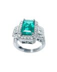Anillo de compromiso de oro blanco 18k con esmeralda colombiana rectangular verde y diamantes.