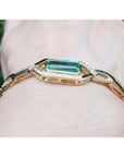 14K yellow gold bracelet with a rectangular emerald and diamond accents on a wrist.