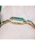 14K yellow gold bracelet with a rectangular emerald and diamond accents on a wrist.