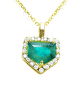 Gold necklace with a heart-shaped emerald pendant on a topside view position.