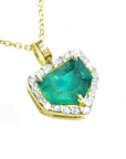 Yellow gold pendant with a natural emerald and diamond accents on a toside view.