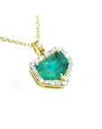 Yellow gold pendant with a natural emerald and diamond accents on a toside view.