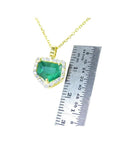 1.75 ct. Colombian emerald pendant with diamond halo on a 14K gold chain, shown with a ruler for scale.