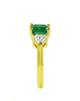18K yellow gold three-stone ring with a vibrant emerald and two trillion-cut diamonds.