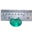3.68 ct GIA certified loose oval emerald, bright bluish-green, displayed with a ruler for scale.