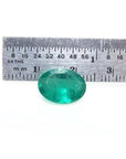 3.68 ct GIA certified loose oval emerald, bright bluish-green, displayed with a ruler for scale.